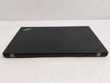the back of a black laptop sitting on top of a white table