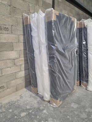 many boxes of mattresses sitting on the sidewalk
