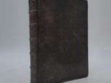 an old book sitting on top of a white surface