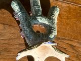 une petite statue représentant une main, posée sur une table en bois