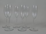 four empty wine glasses are lined up on a white surface