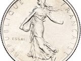 an image of a silver coin with a woman walking on it
