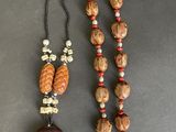 a close up of a necklace and a bead on a table