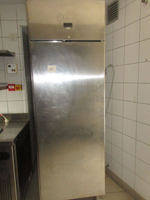 un réfrigérateur en acier inoxydable dans une cuisine aux murs carrelés