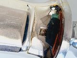 a close up of a silver object with a reflection of a person