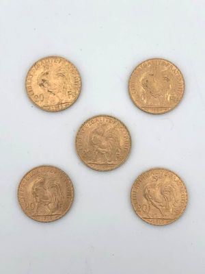 six gold sovereigns of different sizes and shapes on a white surface