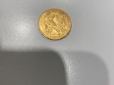 gros plan d'une pièce d'or sur une surface blanche