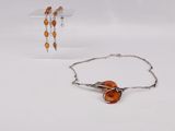 two pieces of jewelry sitting on top of a table next to each other
