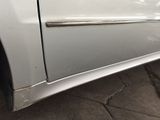 a white car that has a dent in the side of it
