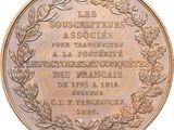 an old bronze medal with a wreath of leaves on it