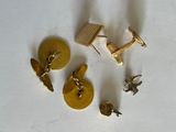 quatre paires de boutons de manchette en or sur un fond blanc