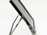 a laptop computer sitting on a stand on a white surface