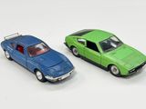 deux voitures jouets assises l'une à côté de l'autre sur une surface blanche