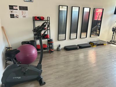 a gym room with exercise equipment and mirrors on the wall