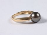 a close up of a ring with a black pearl on it