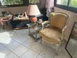 un salon avec un fauteuil et une table sur laquelle se trouve une lampe