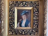 painting of a woman in a blue hat with a pipe in a gold frame