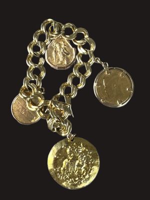 a close up of a chain bracelet with coins on a black background
