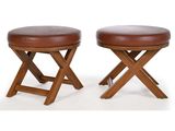 deux tabourets en bois avec des assises en cuir marron sur fond blanc