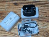 a box of ear buds and a charger on a wooden table