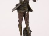 bronze statue of a man holding a bird on a wooden base