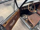 an old car that is sitting in the street