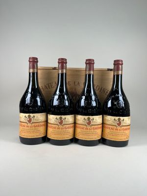 quatre bouteilles de vin dans un coffret en bois posé sur une table