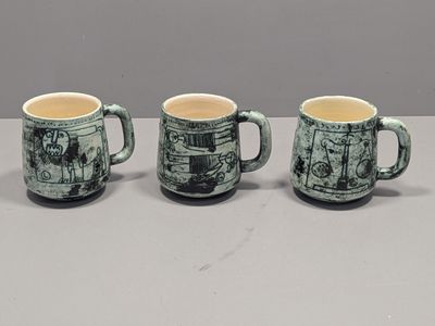 three coffee mugs sitting on top of a table next to each other