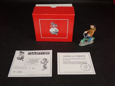 une petite figurine représentant un homme sur un skateboard devant une boîte rouge