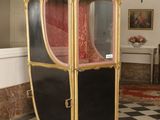 a black and white checkered floor with a gold and red carriage
