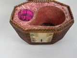 a basket with a cat inside of it on a table