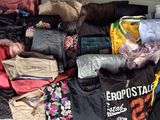 une pile de vêtements posée sur un lit