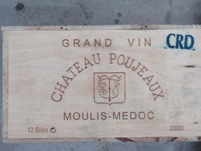 une boîte en bois sur laquelle est collée une étiquette, posée par terre