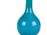 un vase bleu posé sur une surface blanche