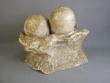 two figurines of two people sitting on a tree stump