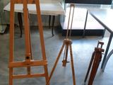 un chevalet en bois posé dans une pièce avec une table et des chaises