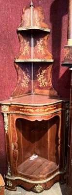 a corner cabinet that has a shelf on top of it