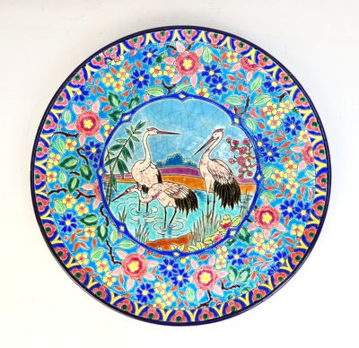 une assiette sur laquelle sont représentés deux oiseaux, posée sur une table