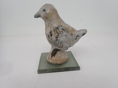 un petit oiseau perché au sommet d'un socle