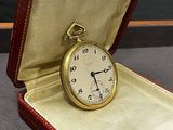 un étui rouge contenant une montre de poche en or