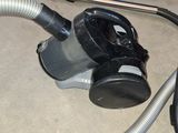 a vacuum that is sitting on the floor next to a hose