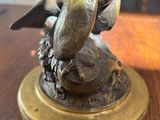 a statue of a bird sitting on top of a wooden table