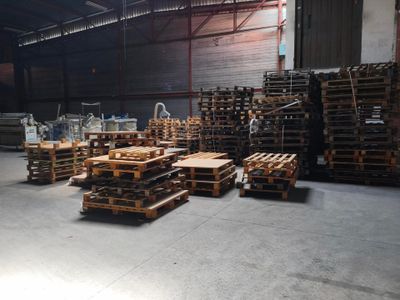 un grand entrepôt avec des palettes de bois au milieu
