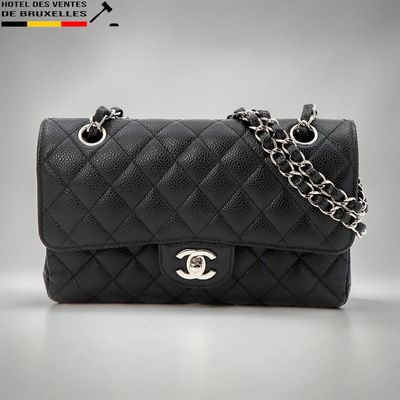 un sac Chanel noir auquel est suspendue une chaîne
