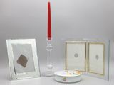 une bougie, un cadre photo et une photo posés sur une table