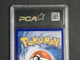 the pokemon card is in a plastic holder on a table