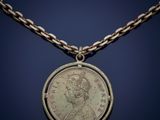 a silver coin with a chain around it on a blue background