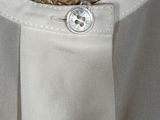 the back of a white shirt with a button on it