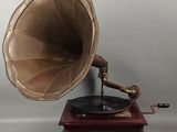 un vieux phonographe avec un socle et un boîtier en bois