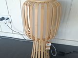 une lampe en bois posée par terre